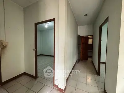 Spacious interior hallway with tiled flooring and multiple doorways in a residential property.