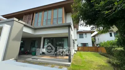 Modern two-story house with spacious garden and patio area, perfect for family living.