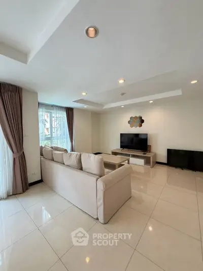 Spacious living room with modern decor and large windows for natural light