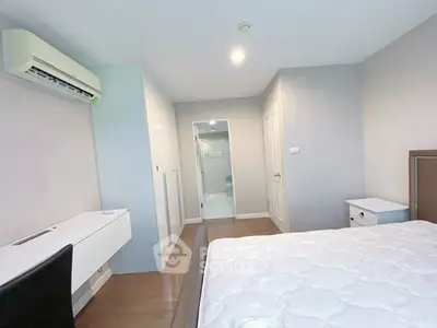 Spacious bedroom with modern furnishings and ample natural light, featuring a sleek air conditioning unit.