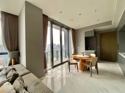 Modern living room with large windows and city view, featuring elegant furniture and stylish decor.