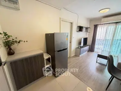 Modern living room with sleek furniture and balcony view, featuring a stylish kitchen area and contemporary decor.