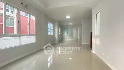 Spacious and bright living area with large windows and glossy tiled floors.