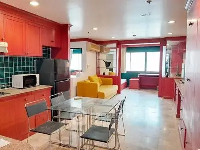 Spacious kitchen and living area with vibrant red cabinetry and modern furnishings.
