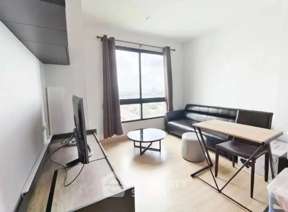Modern living room with sleek furniture and large window offering city views.