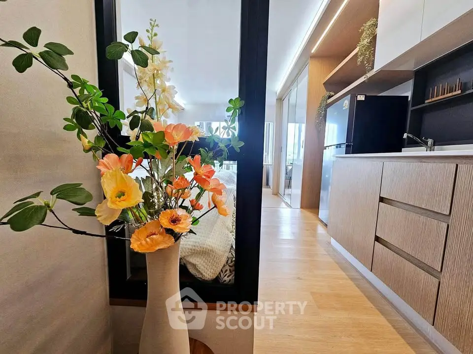 Modern kitchen with sleek cabinetry and vibrant floral arrangement, showcasing contemporary interior design.