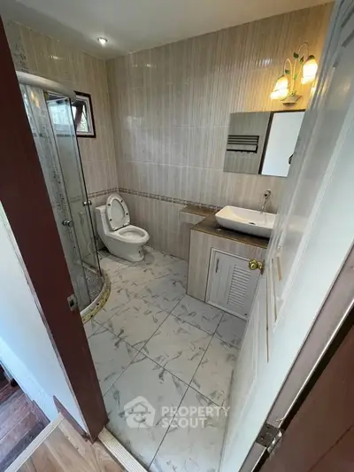 Modern bathroom with glass shower and stylish sink in a cozy home.