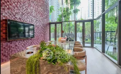 Luxurious modern living room with floor-to-ceiling windows and lush greenery view.