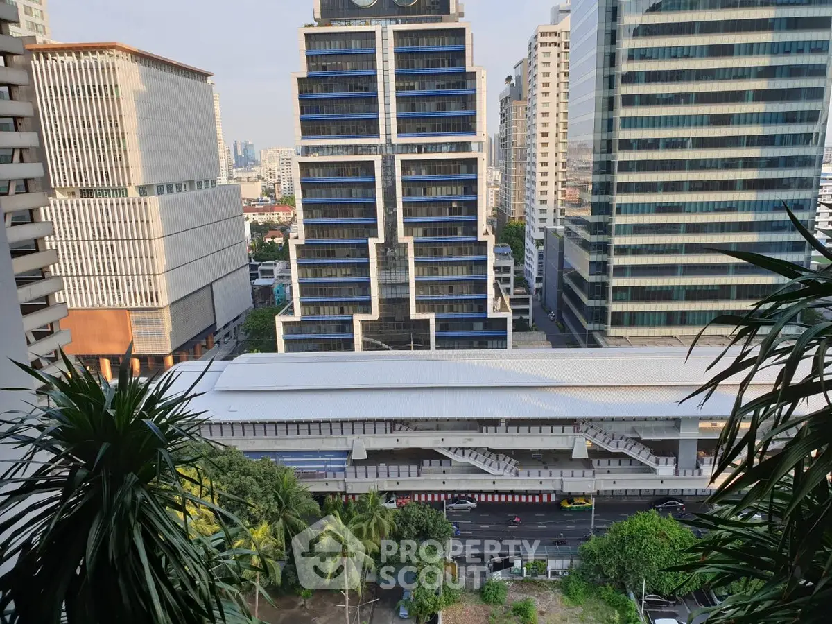 Stunning cityscape view from high-rise building with lush greenery and modern architecture.