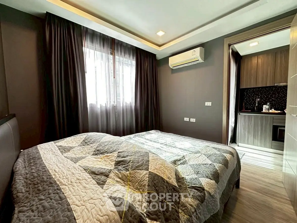 Cozy bedroom with modern decor and adjacent kitchen view