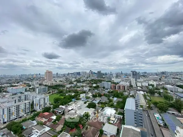 Stunning cityscape view from high-rise building showcasing urban skyline and lush greenery.