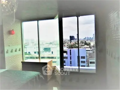 Spacious bedroom with panoramic city view and large windows in modern apartment.