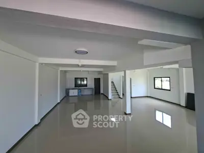Spacious open-plan living area with sleek flooring and modern design, perfect for customization.