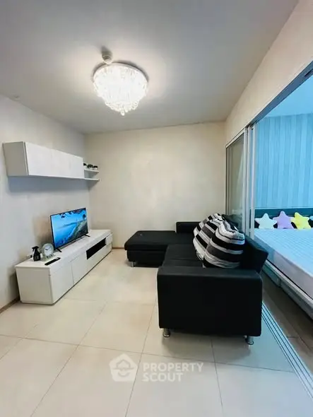 Modern living room with sleek black sofa and stylish chandelier
