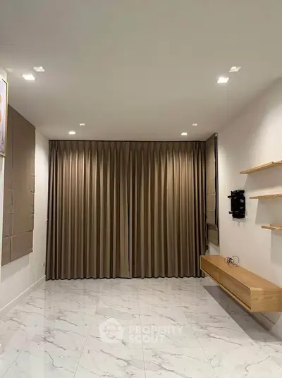 Modern minimalist living room with marble floor and wall-mounted shelves.