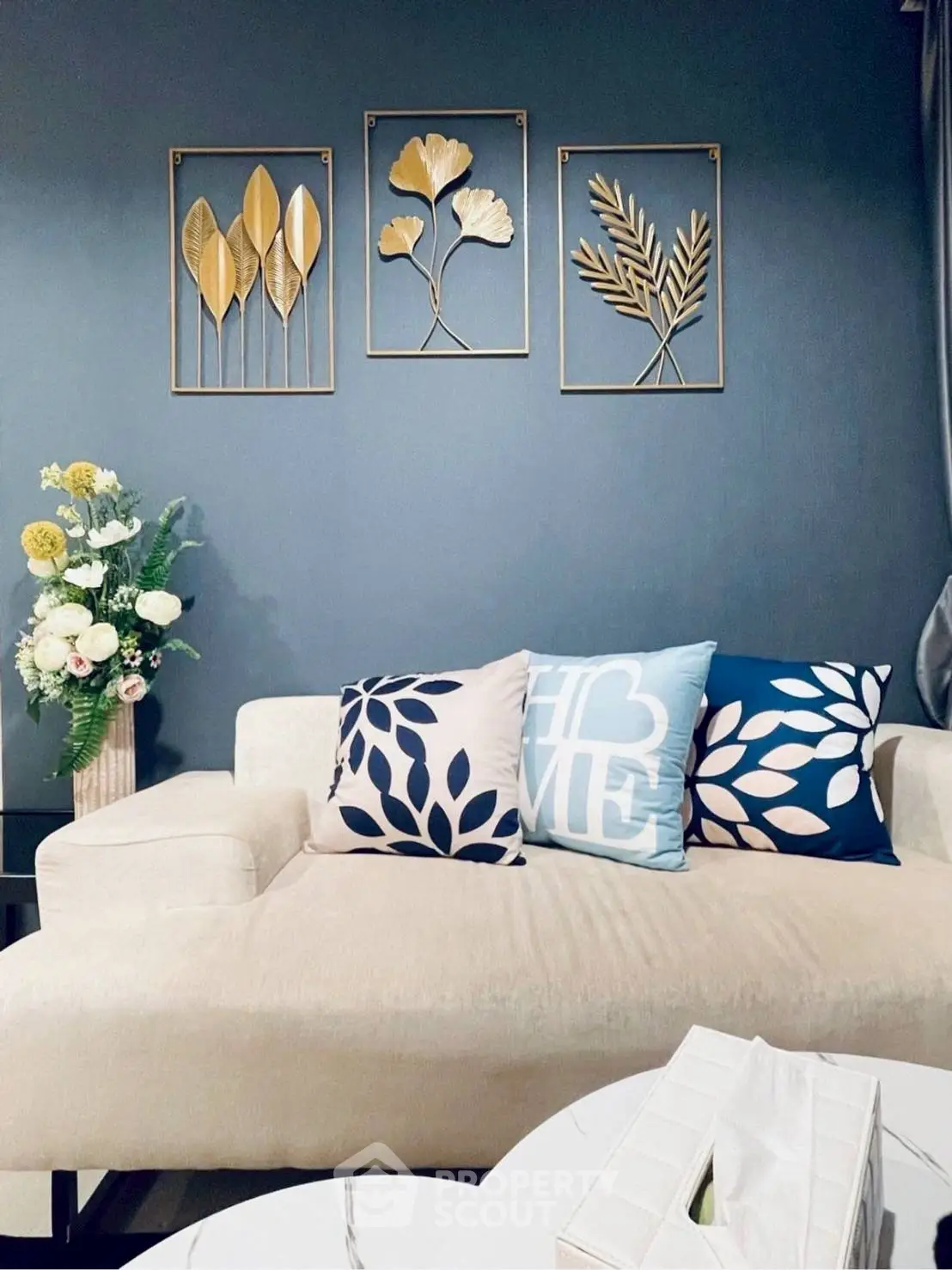 Chic living room with elegant wall art and cozy cushions on a plush sofa.