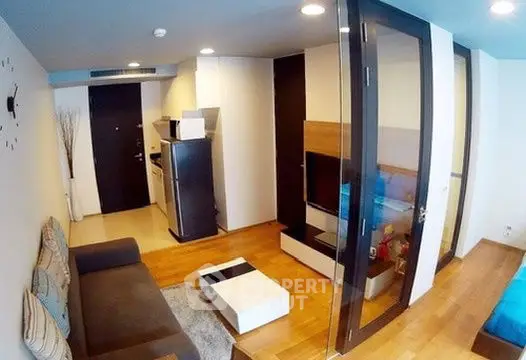 Modern living room with sleek design and open layout, featuring a cozy sofa and stylish decor.