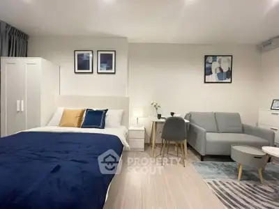 Modern studio apartment with cozy bed and stylish living area, perfect for urban living.