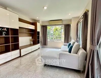 Spacious living room with modern furniture and large windows offering natural light.