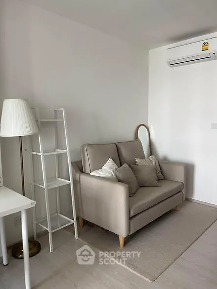 Cozy living room with modern sofa and air conditioning unit, perfect for relaxation.