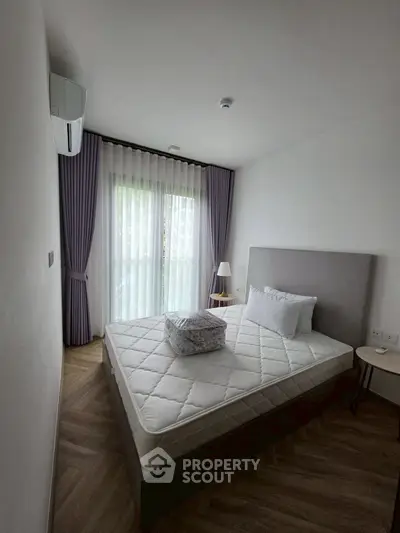 Modern bedroom with natural light, featuring a comfortable bed and stylish decor.