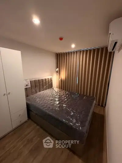 Cozy bedroom with modern furnishings and ambient lighting, featuring a comfortable bed and sleek wardrobe.