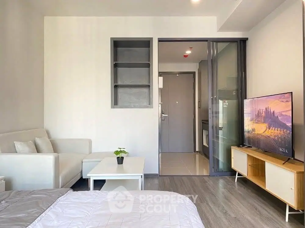 Modern studio apartment with sleek design, featuring a cozy living area and compact kitchen.
