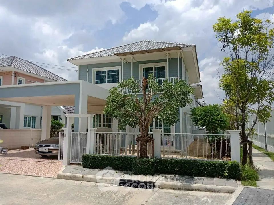 Charming two-story house with a carport and lush greenery in a serene neighborhood.