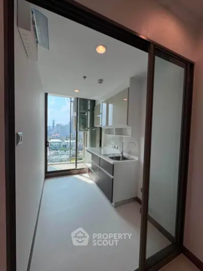 Modern kitchen with sleek design and city view, featuring open layout and ample natural light.
