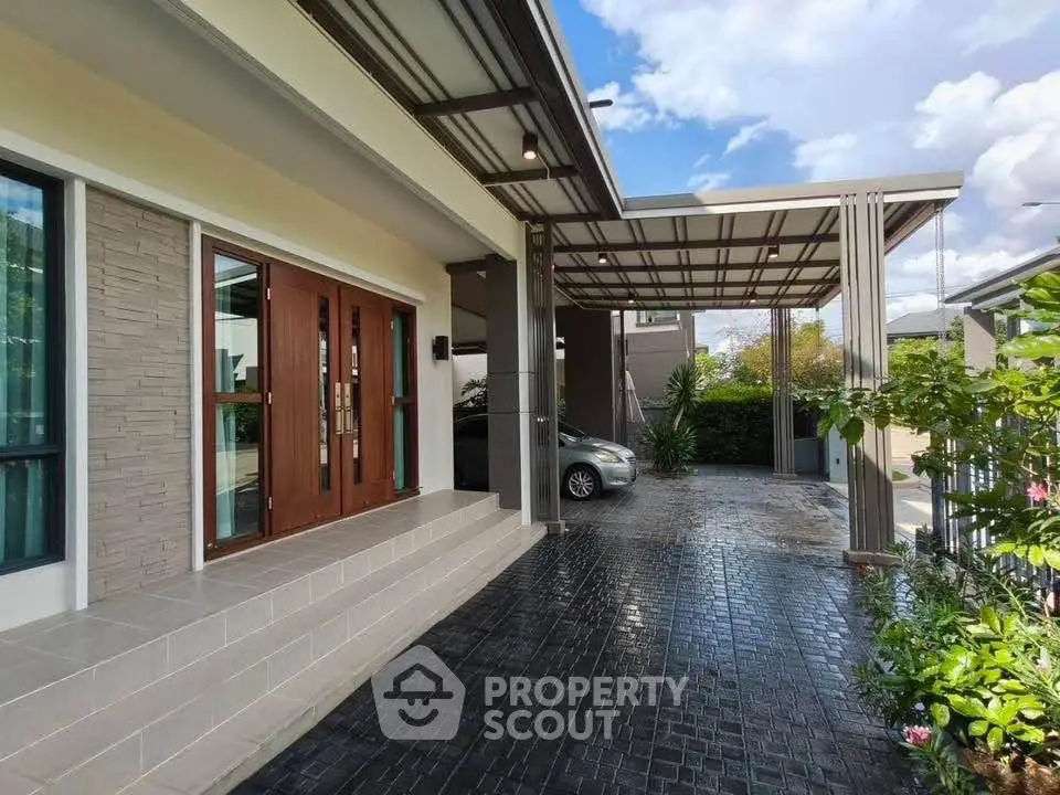 Modern home entrance with covered carport and sleek architectural design.
