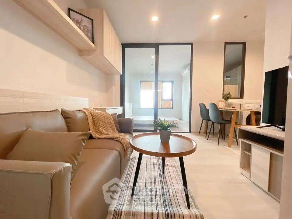 Modern living room with cozy sofa and stylish decor in open-plan apartment.