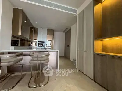 Modern kitchen with sleek cabinetry and built-in appliances, featuring a stylish breakfast bar and contemporary lighting.