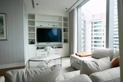 Luxurious living room with large windows and modern entertainment center in high-rise apartment.
