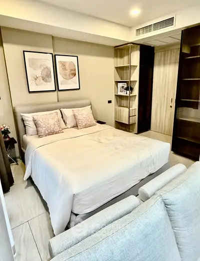 Modern bedroom with elegant decor and cozy ambiance, featuring stylish artwork and plush bedding.