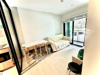 Bright living room with balcony access and modern furnishings in a cozy apartment.
