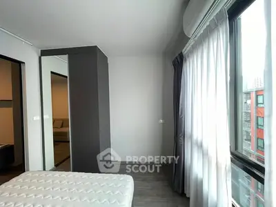 Modern bedroom with large window and natural light in urban apartment