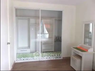 Modern bedroom with sliding wardrobe and vanity set, featuring a clean and minimalist design.