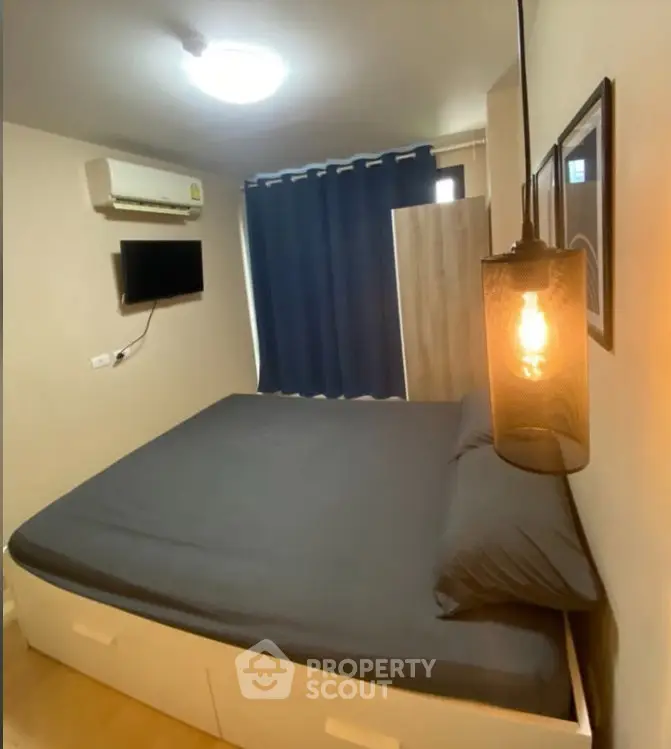 Cozy bedroom with modern lighting and dark curtains, featuring a wall-mounted TV and air conditioning.