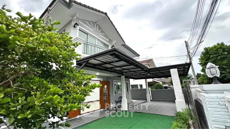 Charming two-story house with lush garden and spacious driveway in a serene neighborhood.