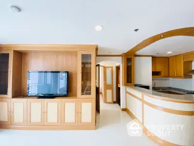 Spacious open-plan living area seamlessly connects to a well-equipped kitchen, featuring ample cabinetry and modern appliances, perfect for entertaining and comfortable living.