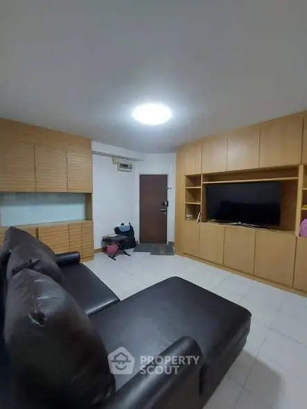 Cozy living room with modern furniture and built-in wooden cabinets, perfect for relaxation and entertainment.