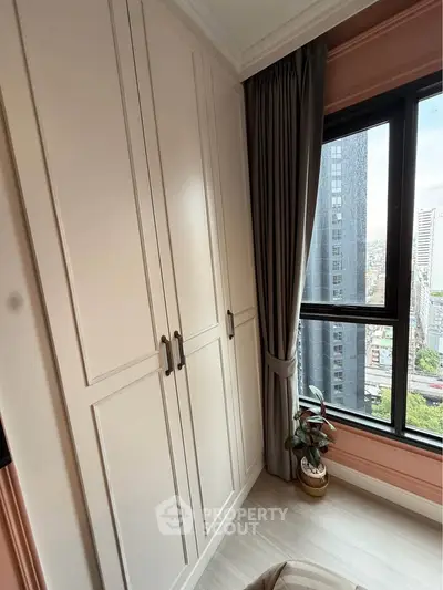 Stylish bedroom with elegant wardrobe and city view from large window