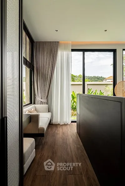 Modern living room with large windows and elegant curtains, offering a serene garden view.