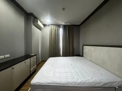 Spacious bedroom with modern design and ample natural light, featuring a large bed and sleek cabinetry.