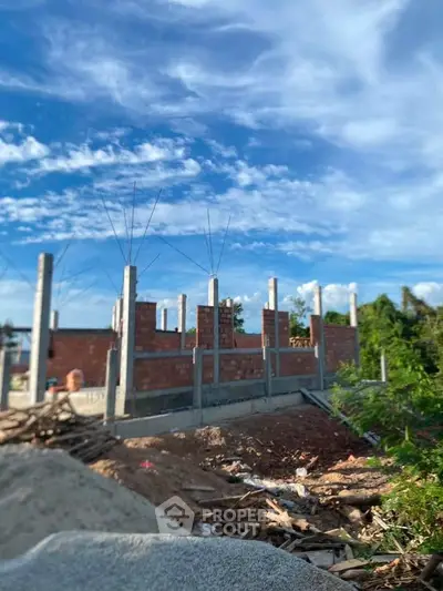 Construction site of a new building under a clear blue sky, showcasing early stages of development.