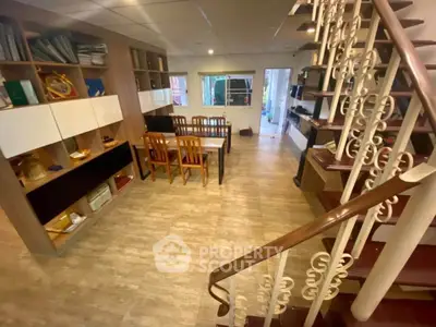 Spacious living room with elegant staircase and modern shelving units