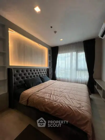 Luxurious bedroom with modern design and large window offering natural light.