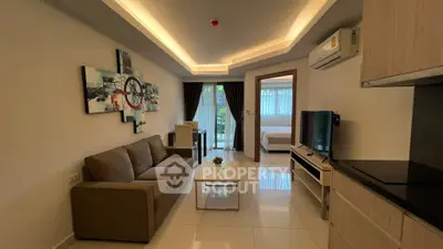 Modern living room with cozy sofa and stylish decor leading to a bright bedroom.