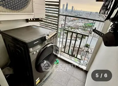 High-rise apartment balcony with washing machine and stunning city view.