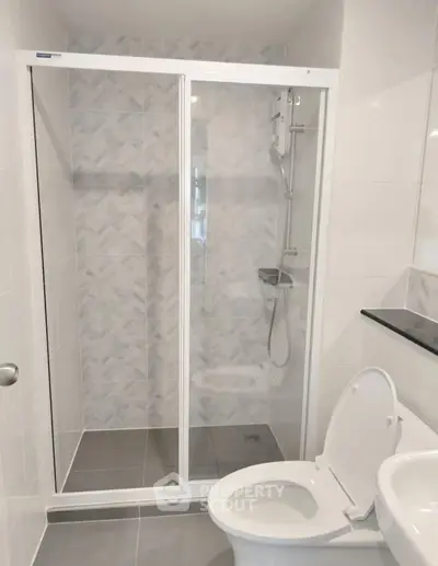 Modern bathroom with glass shower enclosure and sleek fixtures